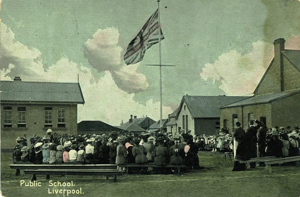 Celebrating Empire Day – early 1900s. The current library is to the left of the picture and classrooms to the right. Photograph from the Liverpool City Library Heritage Collection.